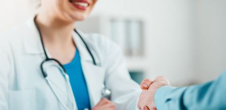 A medical professional shaking hands with a patient